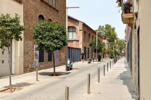 eine Straße mit Bäumen an der Seite eines Gebäudes in der Unterkunft Fabulous One bedroom Apartament in Poble nou in Barcelona
