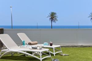 a pair of chairs and a table on a lawn at Chalet Santa Ana 24 by VillaGranCanaria in Playa del Ingles