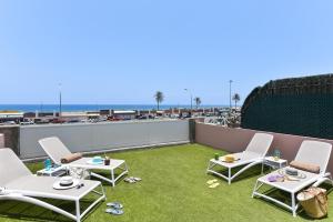 een patio met 2 stoelen en een tafel op een dak bij Chalet Santa Ana 24 by VillaGranCanaria in Playa del Inglés