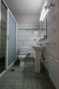 a bathroom with a white toilet and a sink at Panorama Resort in Finikounta