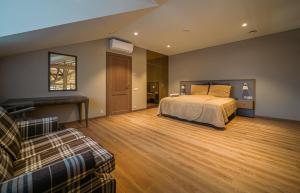 een slaapkamer met een bed en een bank erin bij Royal Horse Resort 