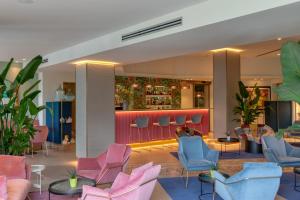 a lobby with pink and blue chairs and a bar at Olivi Hotel & Natural Spa in Sirmione