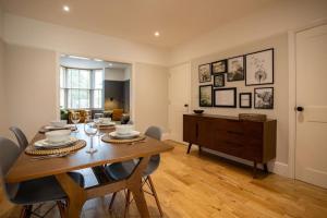 a dining room with a wooden table and chairs at Hereford - Clifton Villa - Beautifully Presented House Located A Short Walk From City Centre - Sleeps 6 Guests - Perfect For Exploring Hereford - Hosted By RENTMYHOUSE in Hereford +32 photos