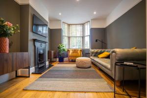 Clifton Villa By RentMyHouse في هيريفورد: غرفة معيشة مع أريكة ومدفأة