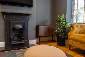 a living room with a fireplace and a chair at Hereford - Clifton Villa - Beautifully Presented House Located A Short Walk From City Centre - Sleeps 6 Guests - Perfect For Exploring Hereford - Hosted By RENTMYHOUSE in Hereford