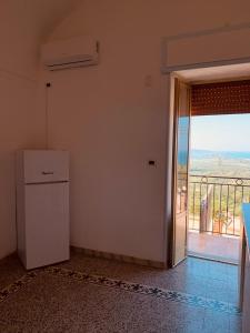 a room with a refrigerator and a door to a balcony at B&B Casa Chicchina in Ischitella