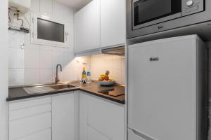 a white kitchen with a sink and a microwave at Over the Sea Los Lisos in Las Palmas de Gran Canaria