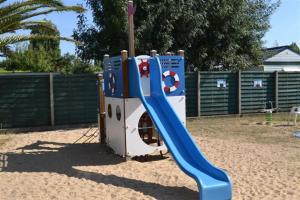 um parque infantil com um escorrega azul numa caixa de areia em Évasion océanique : Mobil-home dans un camping 4* à 50m de l'océan em La Bétaudière