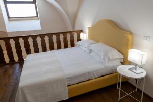 una camera con letto e tavolo con lampada di Palazzo della Contessa - Suites & Breakfast a Lecce