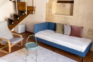 a blue couch and a chair in a living room at Palazzo della Contessa - Suites & Breakfast in Lecce