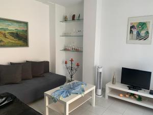 un soggiorno con un divano e una TV di Piso vacacional con piscina en Benicassim a Benicàssim