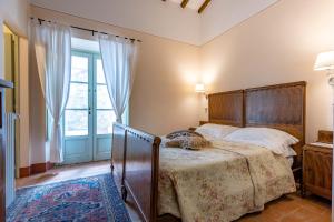 a bedroom with a bed and a large window at Agriturismo I Savelli in Castiglione dʼOrcia