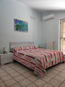 a bedroom with a bed with a colorful blanket on it at Casa Vacanza Riviera dei Saraceni in Trebisacce