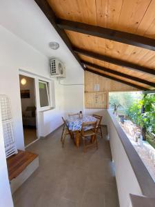 a dining room with a table and wooden ceiling at Apartmani Milka in Vrsi