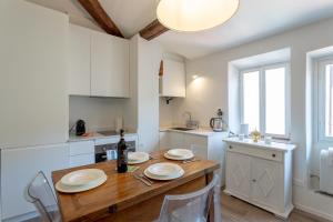 een keuken met een houten tafel en witte kasten bij Piazza Dei Rossi Due View in Florence