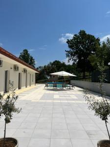 un patio con 2 bancos y una sombrilla en Villa Chiara Piemonte en San Salvatore Monferrato