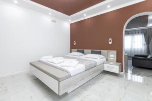 sypialnia z dużym białym łóżkiem i kanapą w obiekcie Apart-Hotel President w Ulcinju