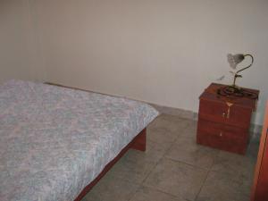 een slaapkamer met een bed en een nachtkastje met een lamp bij Eυχάριστο εξοχικό με όμορφη θέα in Skotina