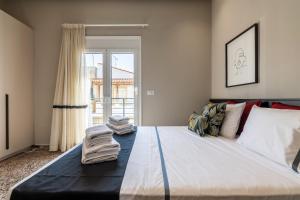 1 dormitorio con 1 cama grande y toallas. en Andrews Luxury Suites Near The Airport, en Heraclión