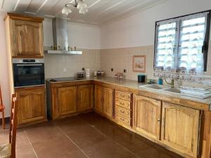 una cucina con armadi in legno, lavandino e finestra di Le refuge d'Aiden a La Plaine-des-Palmistes