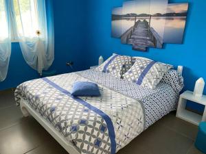 1 dormitorio con 1 cama con pared azul en Le refuge d'Aiden, en La Plaine-des-Palmistes