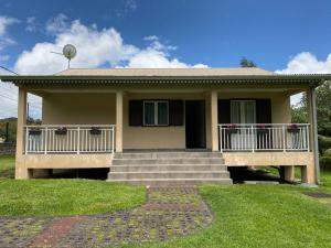 a house with a porch and stairs in front of it at Le refuge d'Aiden in La Plaine des Palmistes