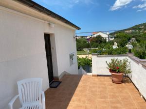 a balcony of a house with two white chairs at Guesthouse Šimag in Rab