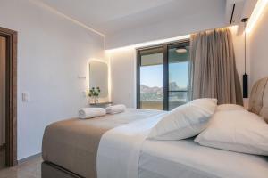 a bedroom with a large bed with a large window at Epsilon Villa, Private Swimming Pool Garden, Panoramic Sunset in Rethymno Town
