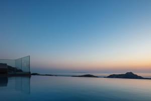a pool of water with the ocean in the background at Epsilon Villa, Private Swimming Pool Garden, Panoramic Sunset in Rethymno