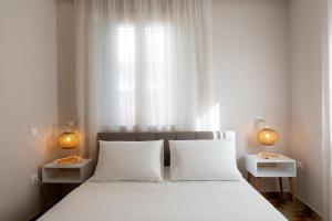 a bedroom with a white bed with two night stands at La Calma in Argostoli