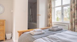 a bedroom with a bed with two towels on it at Briar Cottage in Rusland +11 photos