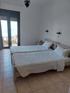 a bedroom with a large bed and a large window at Corali Studios & Portobello Apartments in Elounda