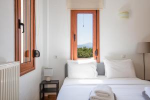 1 dormitorio con 2 camas blancas y ventana en Villa Elesia, en Koxaré
