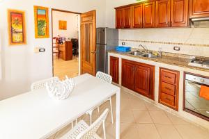 Hotel Villa Capri في بوكا شيكا: مطبخ بدولاب خشبي وطاولة بيضاء