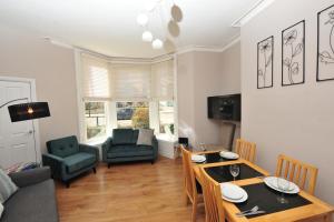 a living room with a table and chairs and a couch at Harrogate Self Catering -Harrogate Convention View - Private Parking in Harrogate