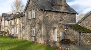 an old stone building with a picnic table in front of it at Briar Cottage in Rusland