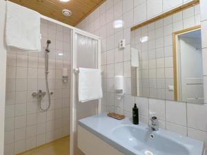 a bathroom with a sink and a shower with a mirror at Gasthaus Wiurila in Halikko
