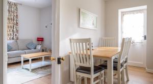 a dining room and living room with a table and chairs at Briar Cottage in Rusland