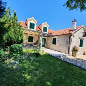 a house with a green door and a yard at Villa Giardino in Drinovci