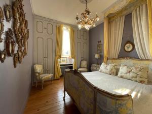 a bedroom with a bed and a chandelier at Maison d'Hercule in Mayenne