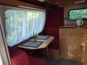 une petite table à l'arrière d'un rv avec une fenêtre dans l'établissement Przyczepa Kempingowa Niewiadów nad morzem Chłapowo, à Władysławowo