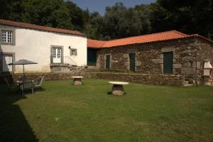 un edificio in pietra con due panchine in un cortile di Casa de Simaens a Felgueiras