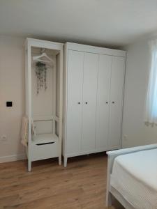 a bedroom with a white cabinet and a bed at MARKA I PERE in Studenci