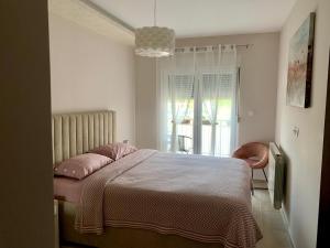 - une chambre dotée d'un lit avec des oreillers roses dans l'établissement Apartman Get Rest, à Žabljak