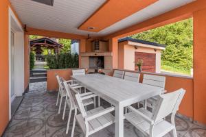 einen Tisch und Stühle auf einer Terrasse mit Kamin in der Unterkunft Villa Tratea - With Pool in Tomić Draga