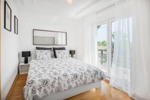 a white bedroom with a bed and a window at Villa Tratea with a heated pool in Tomić Draga