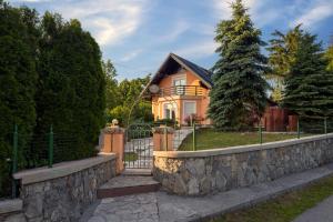 a house with a stone wall and a fence at Villa Tratea - With Pool in Tomić Draga