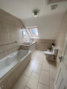 ein Badezimmer mit einer Badewanne, einem WC und einem Waschbecken in der Unterkunft Pilgrim Hotel in Hereford