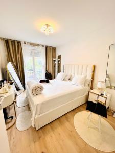 een slaapkamer met een groot wit bed en een spiegel bij LES RÉSIDENCES DE DJIBRIL in Le Blanc-Mesnil