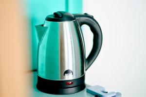 a green and black tea kettle sitting on a counter at Peaceful and Calm place in Lucena